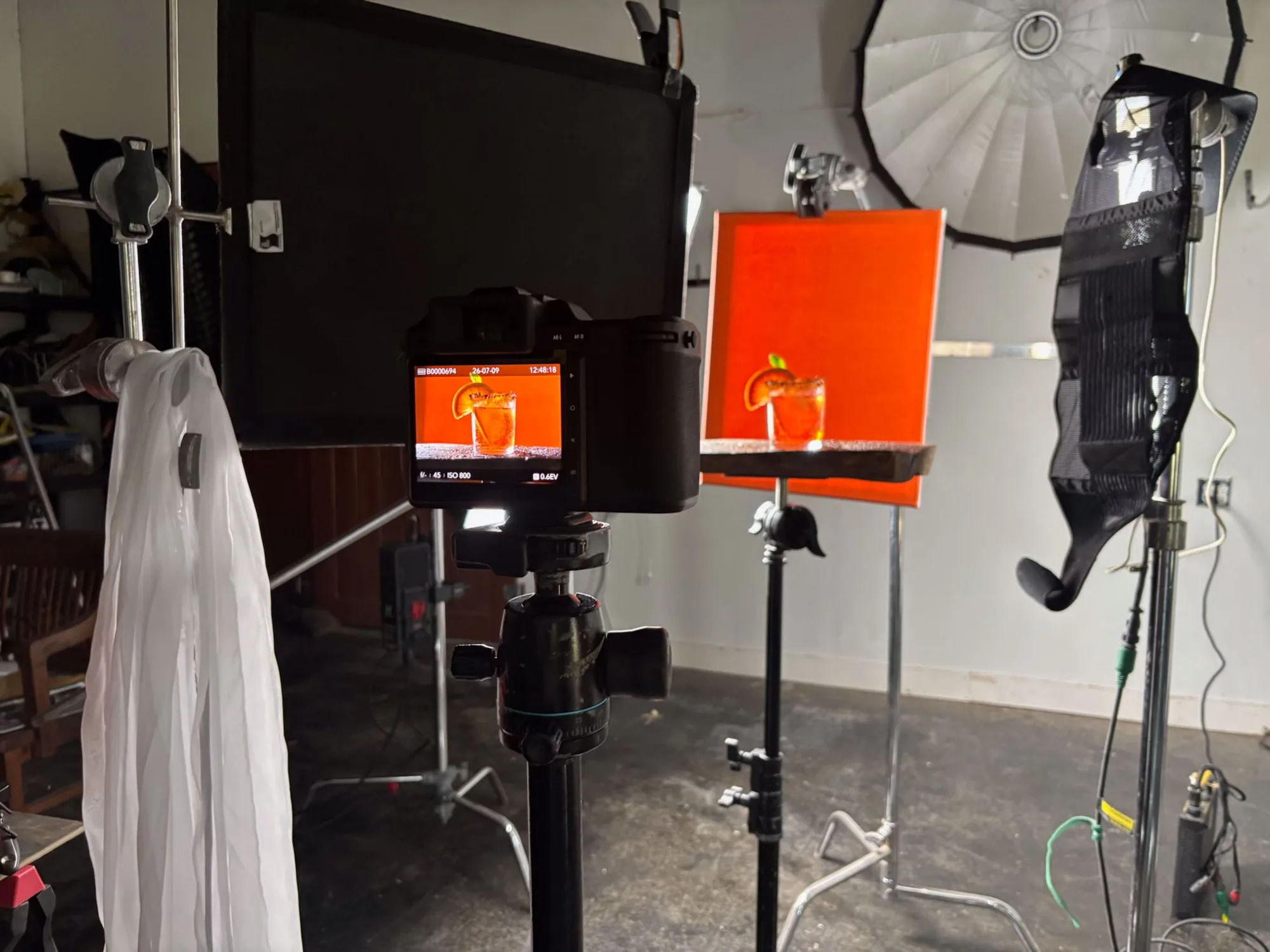 Studio lighting stands, orange backdrop and camera monitor on a food photography set - Raging Bull Food Photography