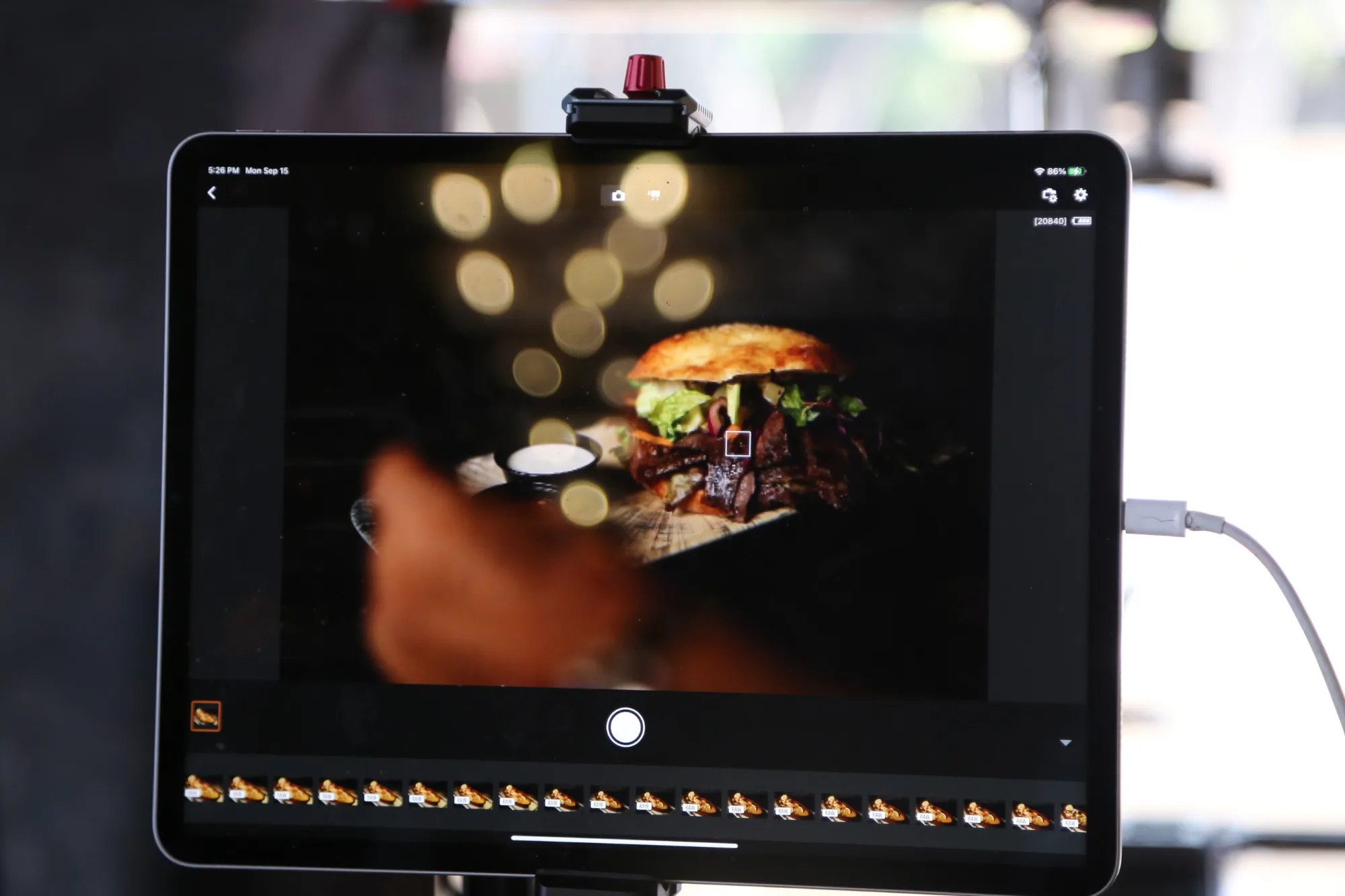 Behind the scenes of a food shoot with the camera monitor framing a plated burger - Raging Bull Food Photography